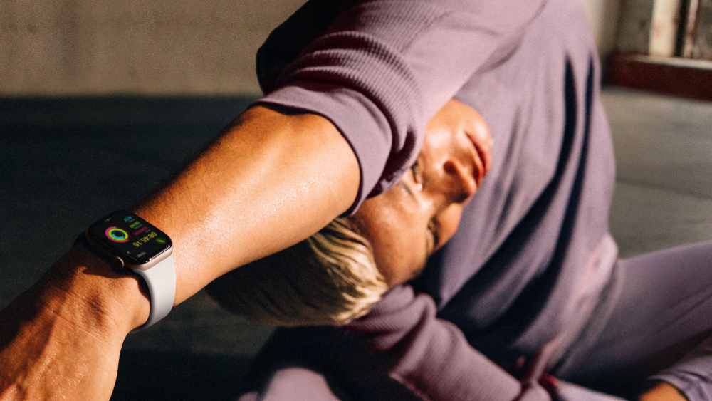 women performing stretches wearing Apple smartwatch