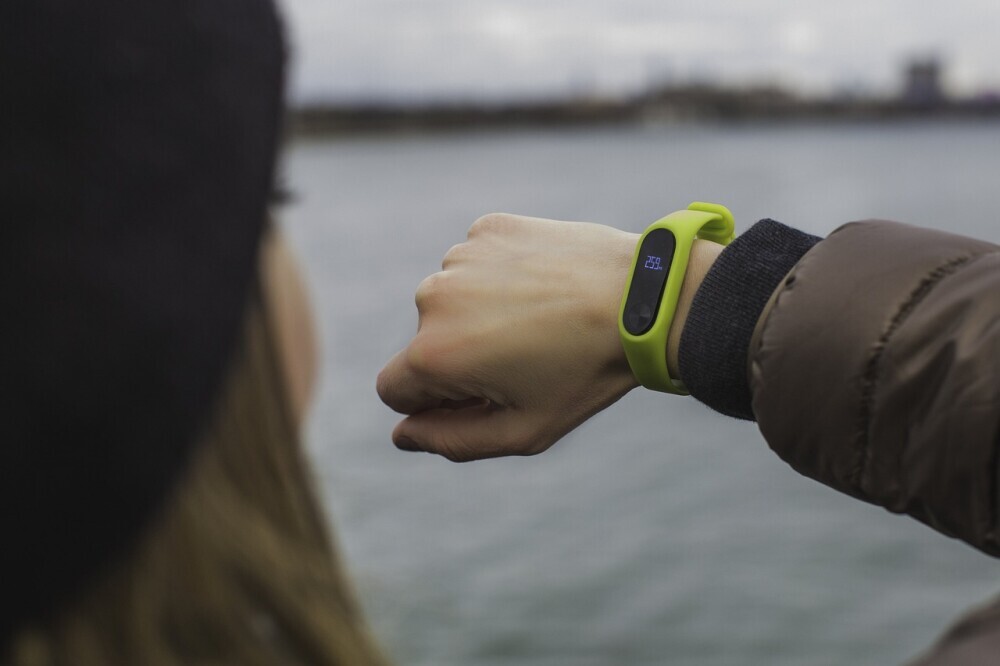 woman taking a glance at her wearable fitness tracker